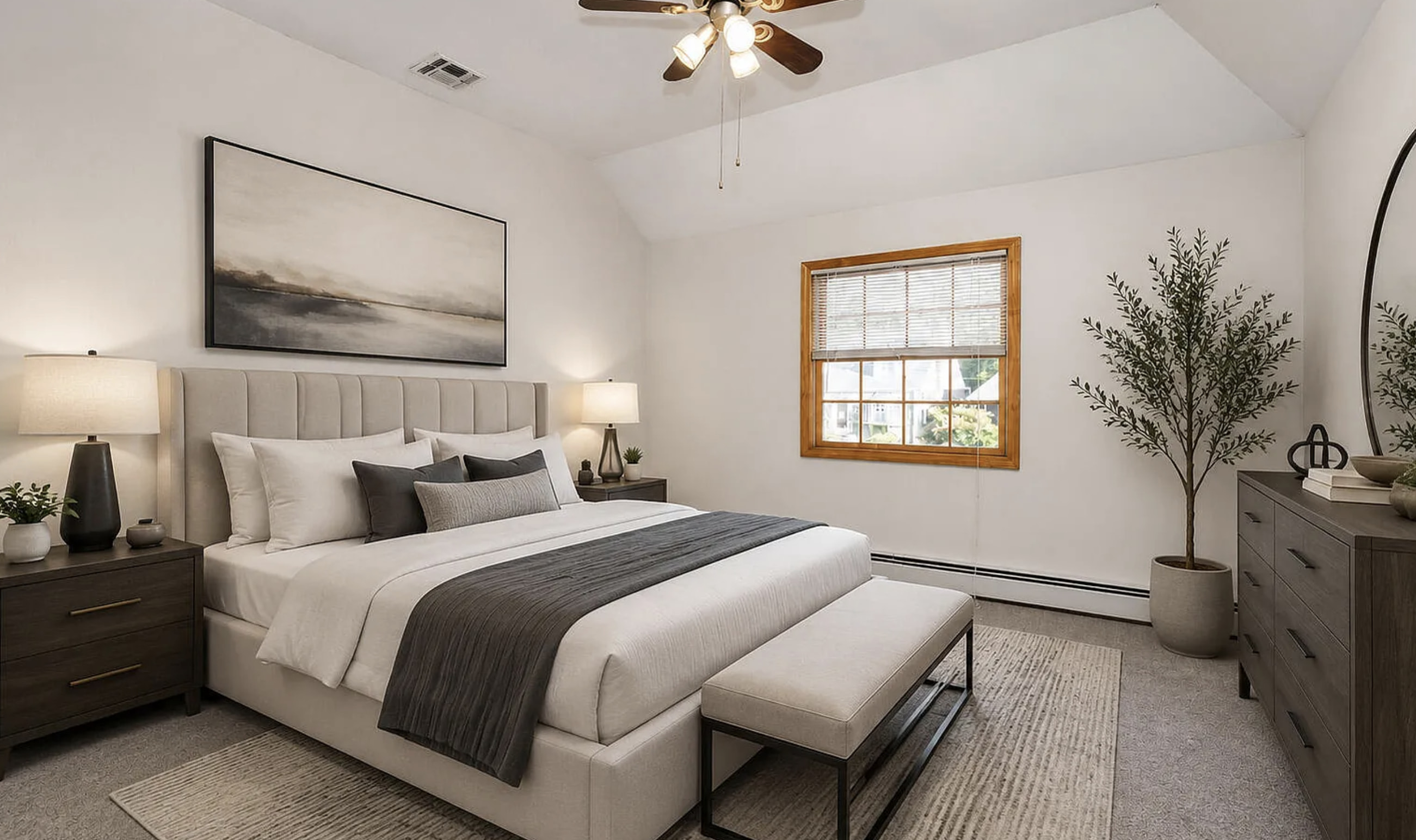 This serene bedroom features a vaulted ceiling with a ceiling fan, creating an airy and spacious feel. The centerpiece is a large, upholstered bed with a tall, tufted headboard,...