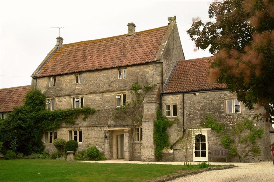 This expansive farmhouse presents a classic and enduring facade, constructed with substantial, rough-hewn stone blocks that speak to its historical roots. The multi-story struct...